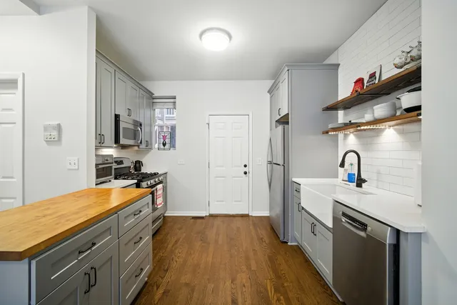 a kitchen with stainless steel appliances a sink stove and refrigerator
