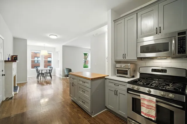 a kitchen with stainless steel appliances a stove a sink cabinets and a dining table