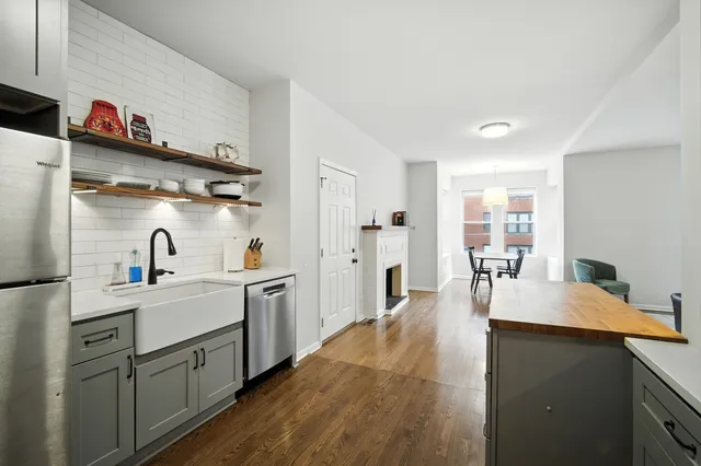 a kitchen with white cabinets and sink