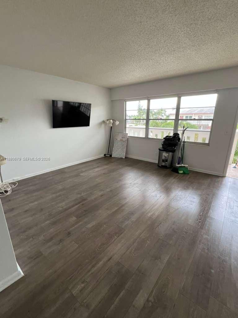 82 Fanshaw B, Unit 82 Boca Raton, FL 33434 - Photo 5 of 7 an empty room with wooden floor and windows