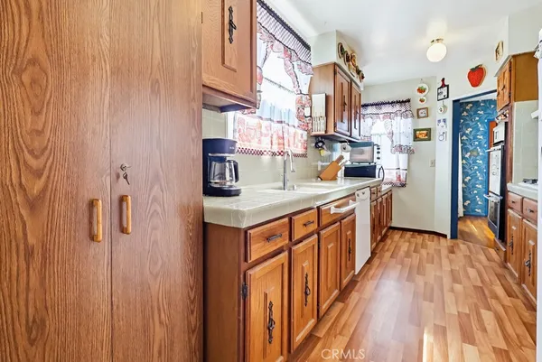 a kitchen with stainless steel appliances granite countertop a refrigerator a stove and a wooden floor