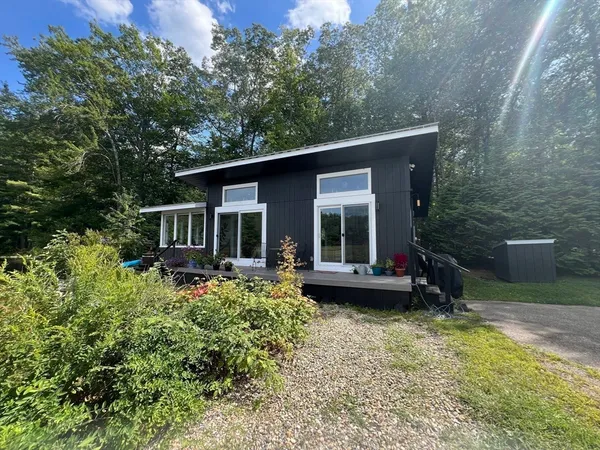 a kitchen with stainless steel appliances kitchen island granite countertop a refrigerator a stove a sink dishwasher and a dining table with wooden floor