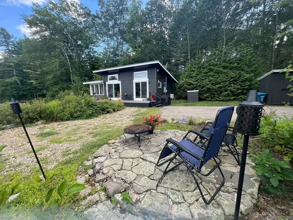 a view of a house with backyard and sitting area