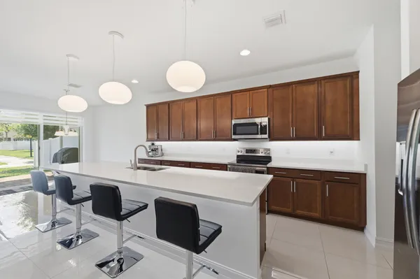 a kitchen with stainless steel appliances a stove a sink cabinets and a refrigerator