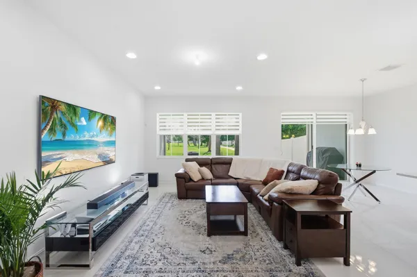 a living room with furniture flat screen tv and a large window