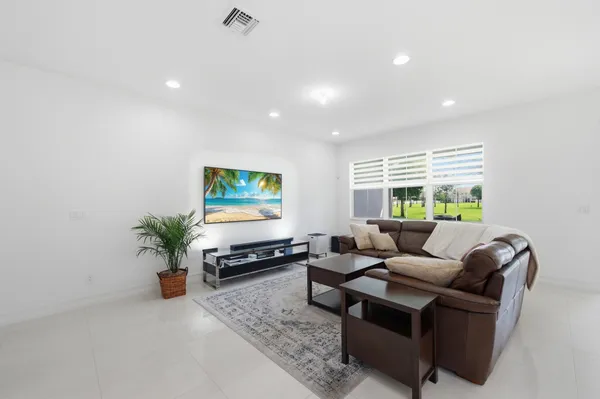 a living room with furniture a window and a flat screen tv