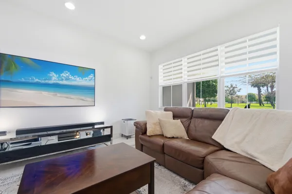 a living room with furniture and a open kitchen view