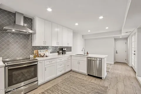 a kitchen with a dining table chairs wooden floor appliances and cabinets
