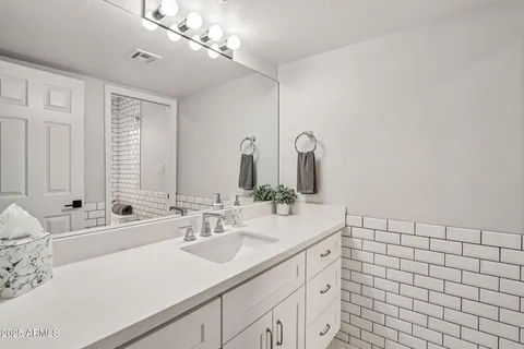a bathroom with a sink a bathtub and next to a window