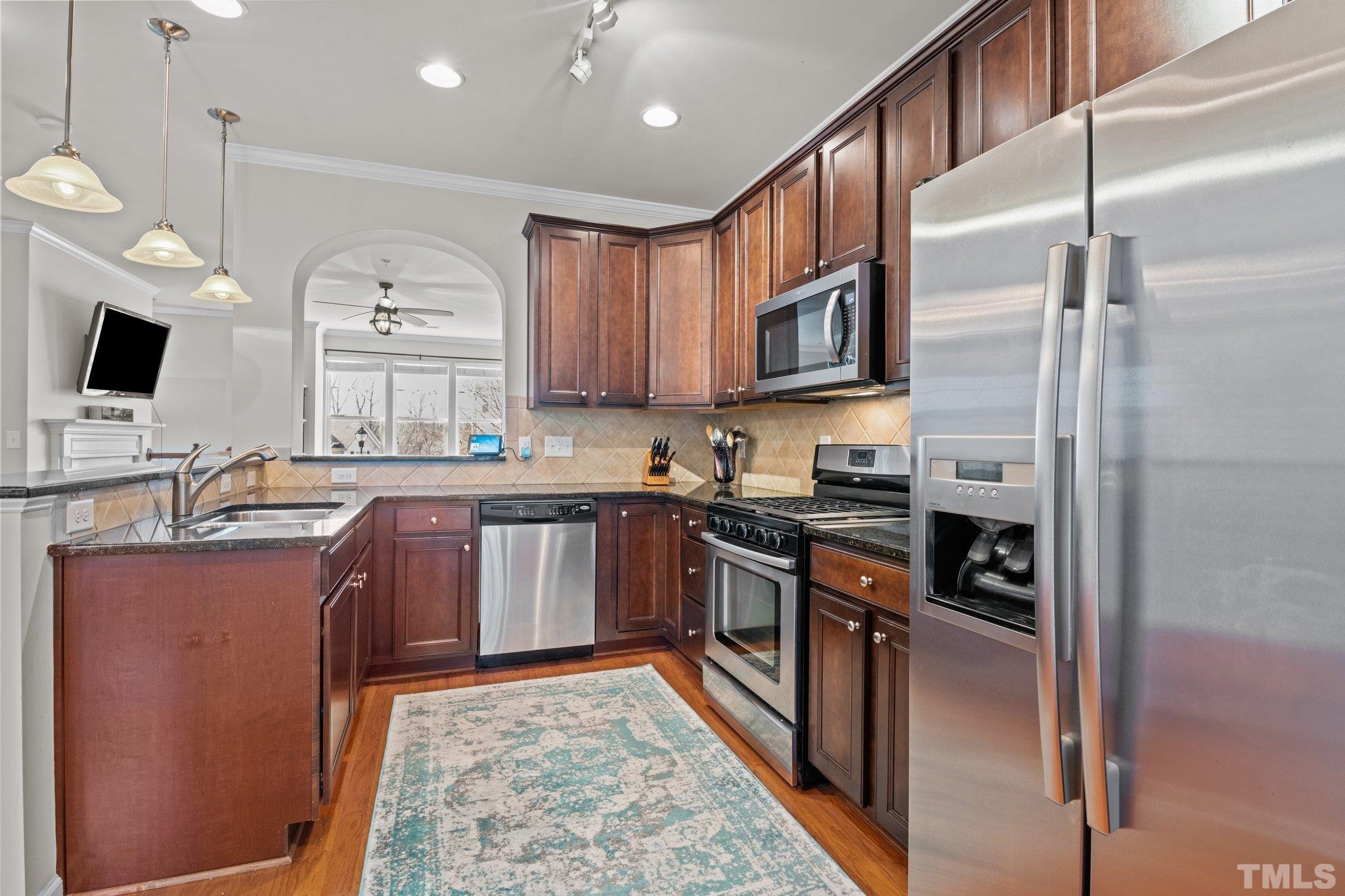 6104 Braidwood Court Raleigh, NC 27612 - Photo 14 of 31 a kitchen with stainless steel appliances granite countertop a stove a sink dishwasher a refrigerator and a microwave