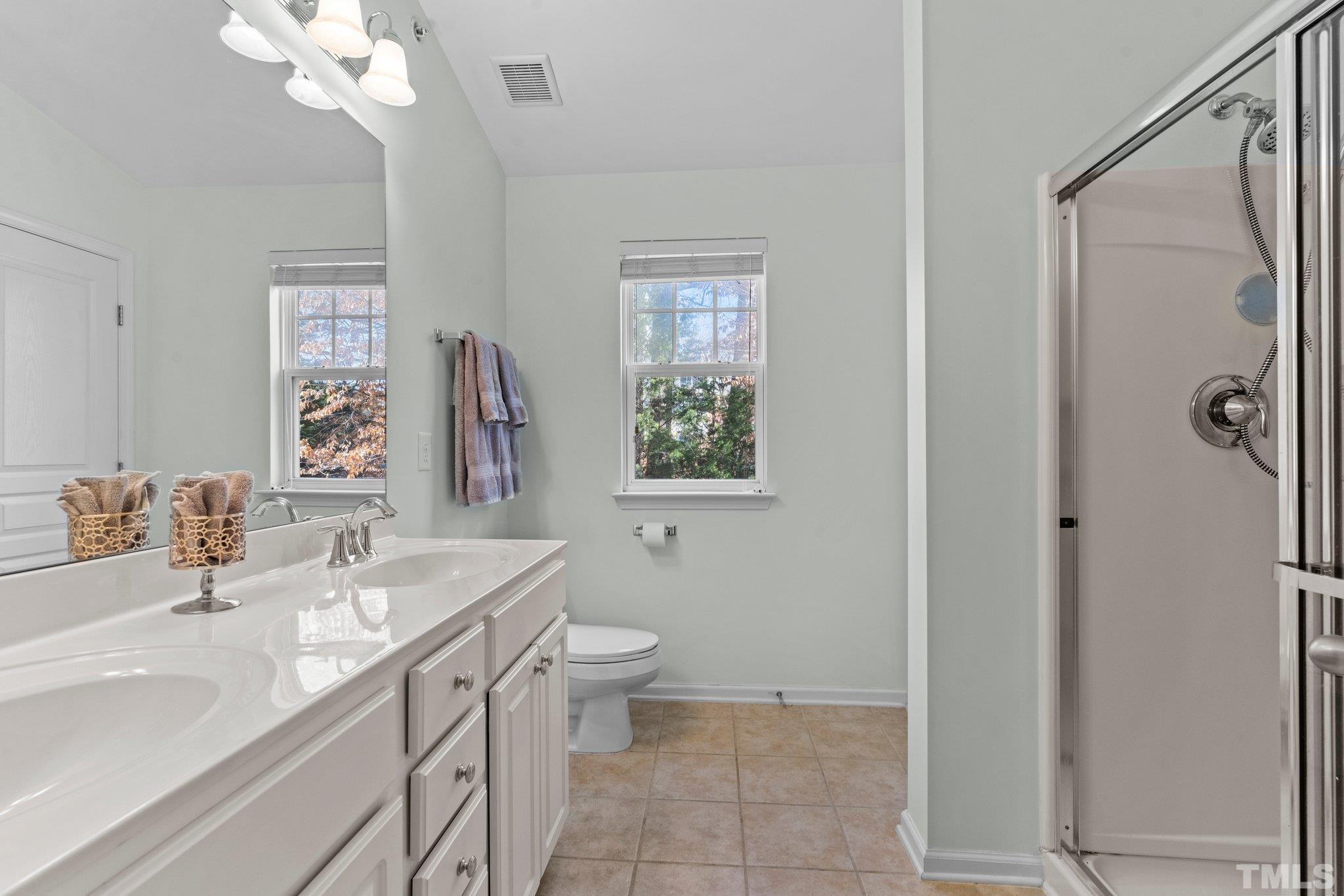 6104 Braidwood Court Raleigh, NC 27612 - Photo 26 of 31 a bathroom with a sink a toilet and a mirror