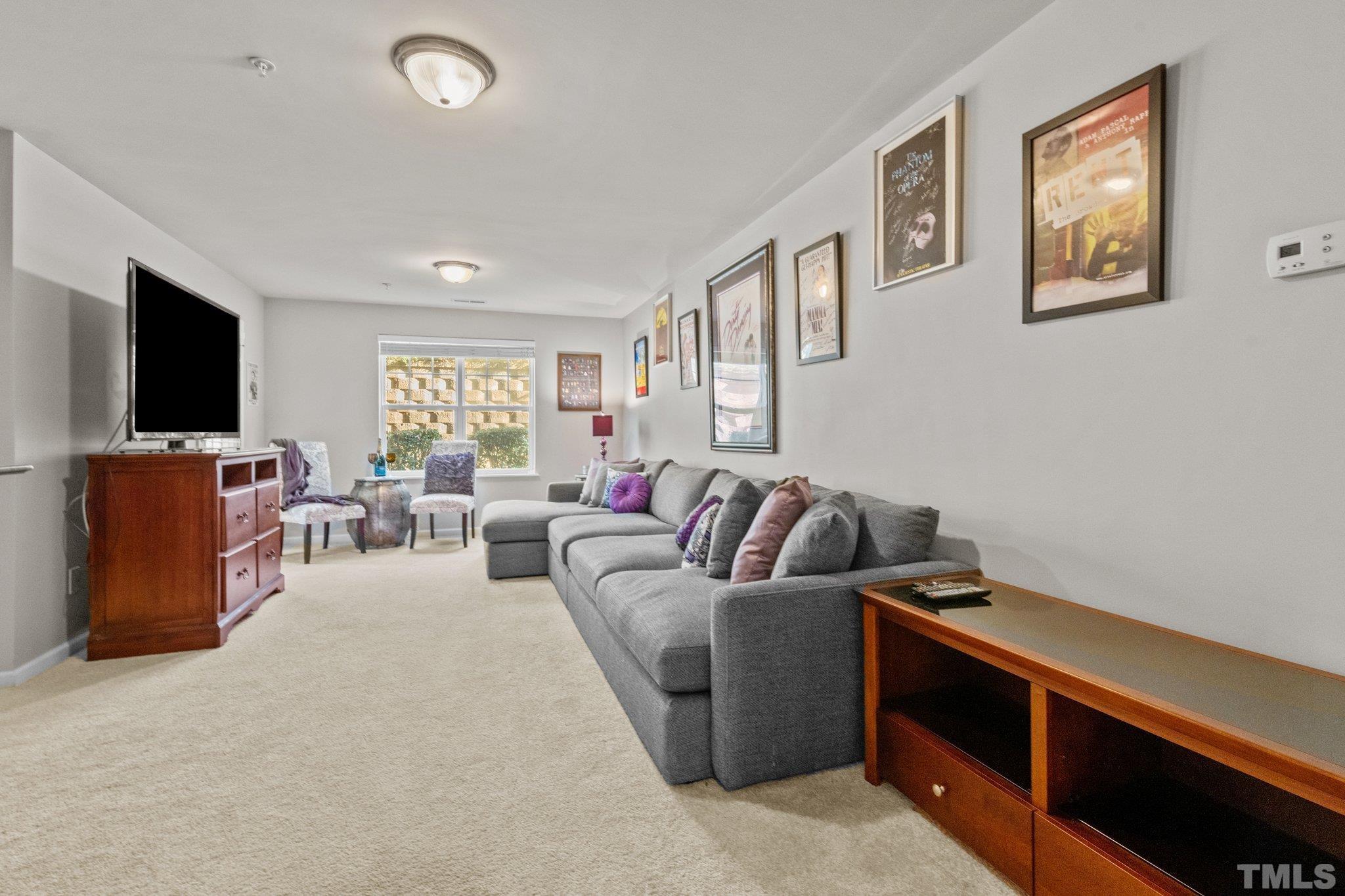 6104 Braidwood Court Raleigh, NC 27612 - Photo 3 of 31 a living room with furniture and a flat screen tv