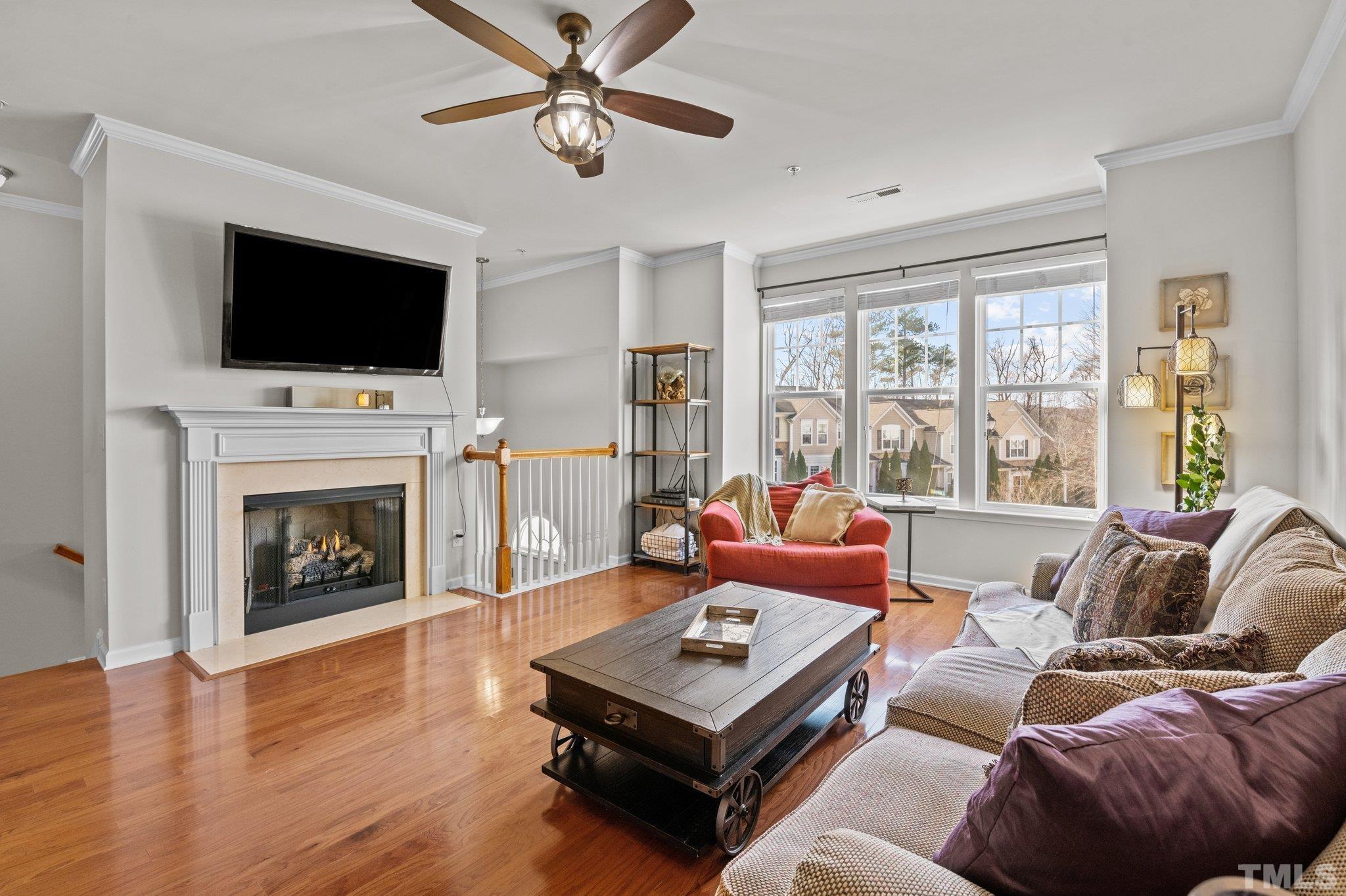 6104 Braidwood Court Raleigh, NC 27612 - Photo 4 of 31 a living room with furniture a flat screen tv and a fireplace