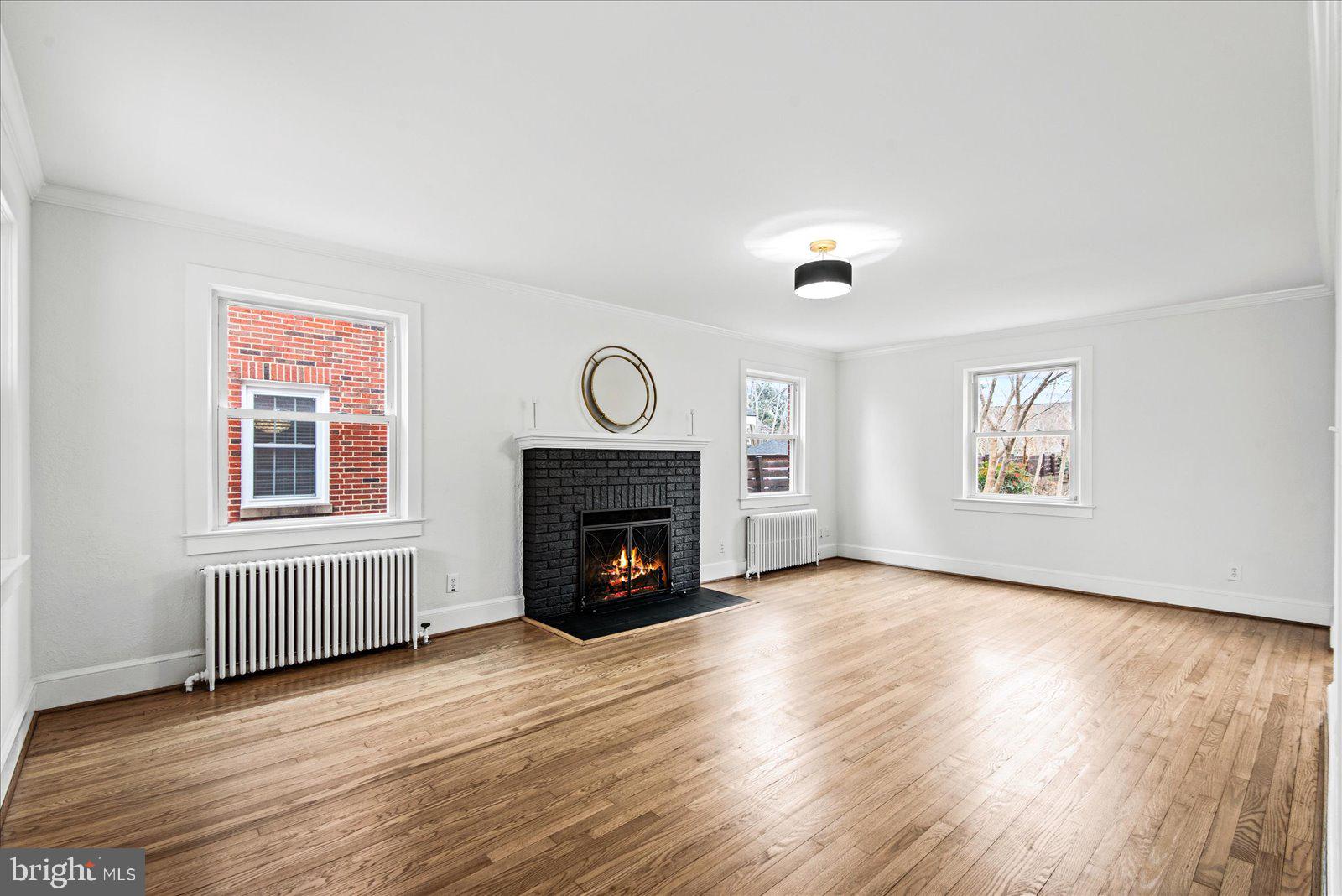 1312 Rowe Street Fredericksburg, VA 22401 - Photo 8 of 45 an empty room with windows a fireplace and wooden floor