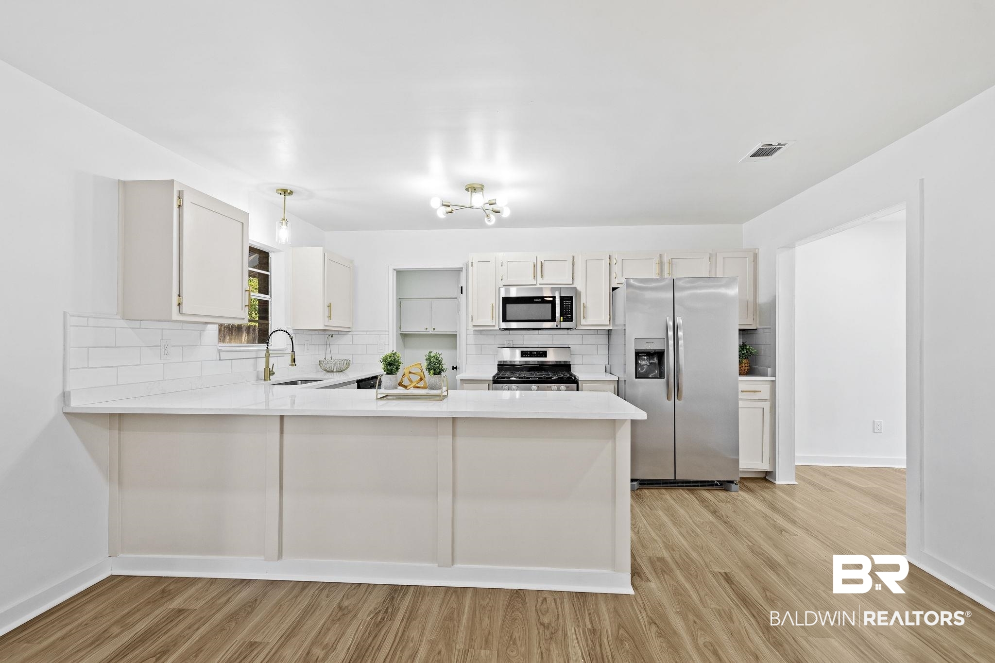 5398 Quail Run North Theodore, AL 36582 - Photo 9 of 46 Kitchen featuring white cabinets, sink, kitchen peninsula, and stainless steel appliances