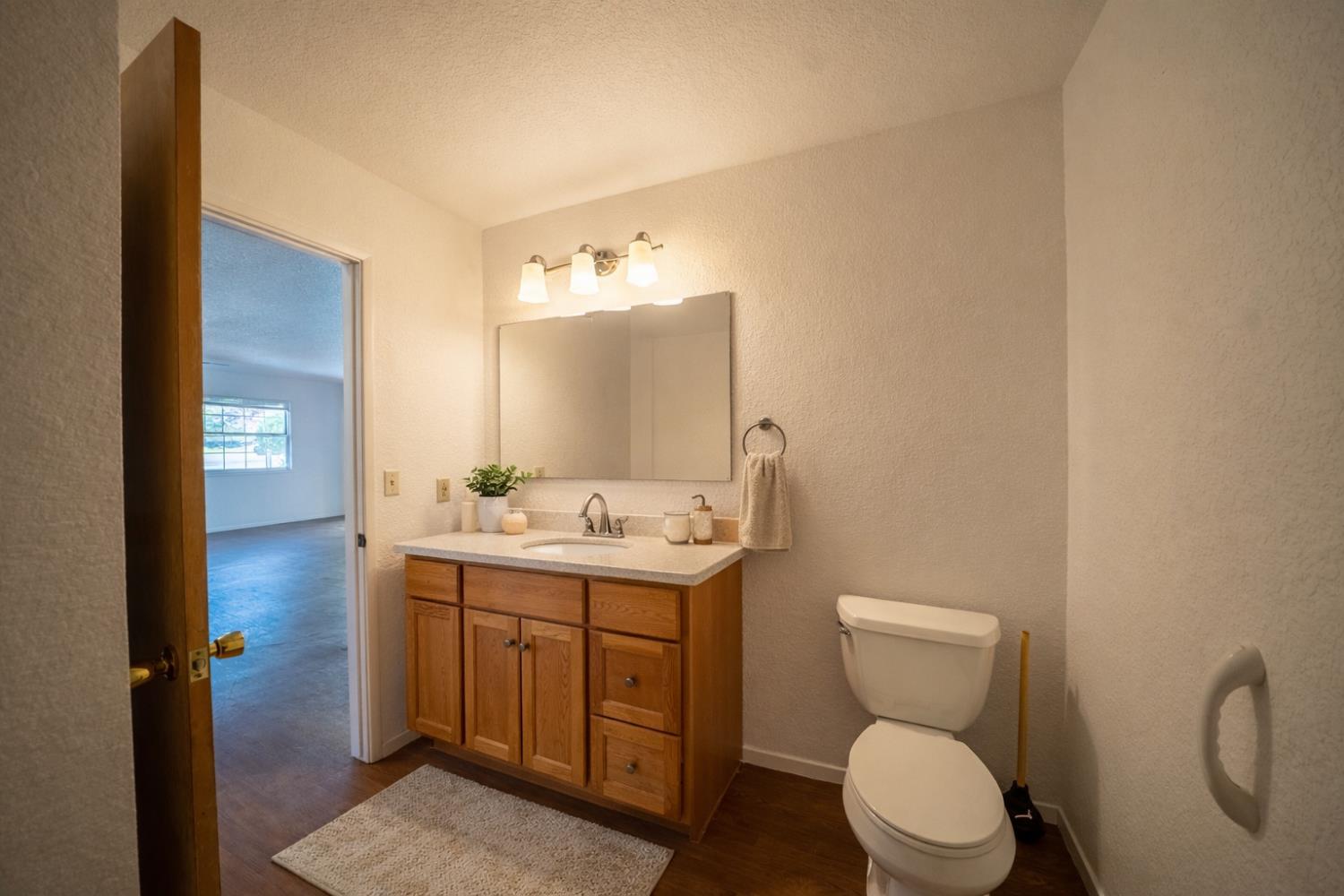 494 Surrey Court Murphys, CA 95247 - Photo 36 of 76 a bathroom with a toilet sink and mirror