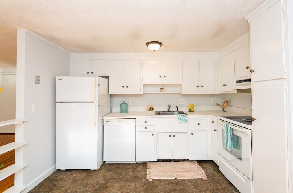 82 Renwick Road, Unit A Wakefield, MA 01880 - Photo 14 of 34 a kitchen with white cabinets and white appliances