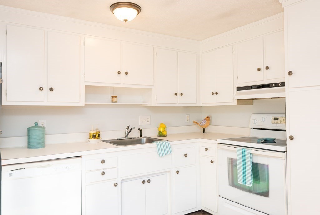 82 Renwick Road, Unit A Wakefield, MA 01880 - Photo 15 of 34 a kitchen with white cabinets and appliances