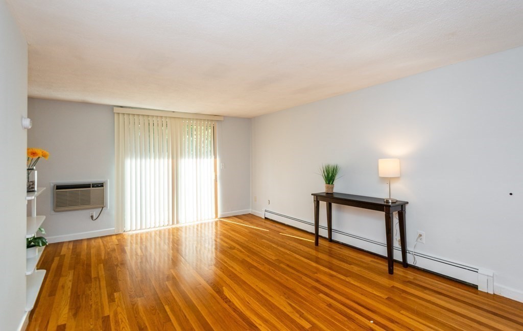 82 Renwick Road, Unit A Wakefield, MA 01880 - Photo 7 of 34 a view of an empty room with wooden floor and a window