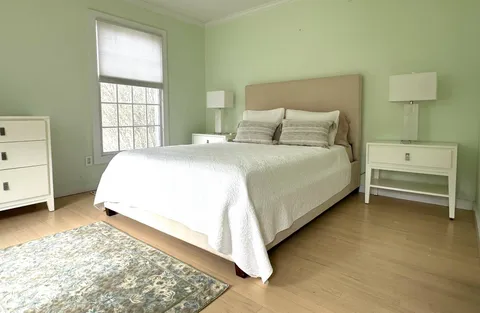 a bathroom with a granite countertop toilet a sink and a large mirror