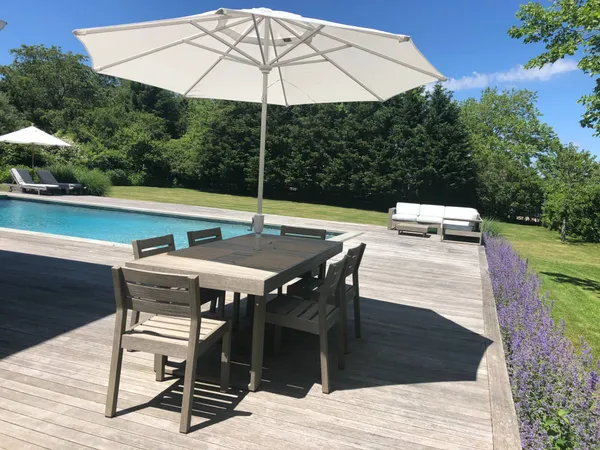 a patio with a table and chairs under an umbrella