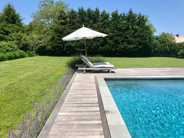 a swimming pool with outdoor seating and garden