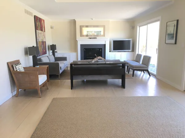 a living room with furniture a large window and a fireplace