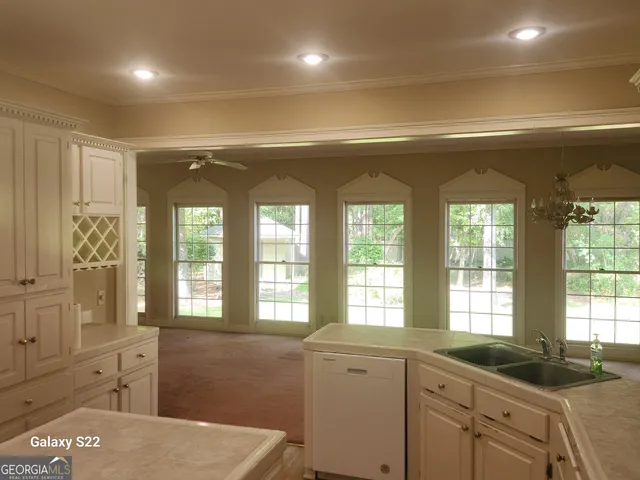 a kitchen with a sink and large windows