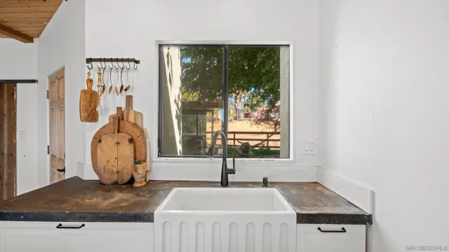 a bathroom with a granite countertop sink and a window