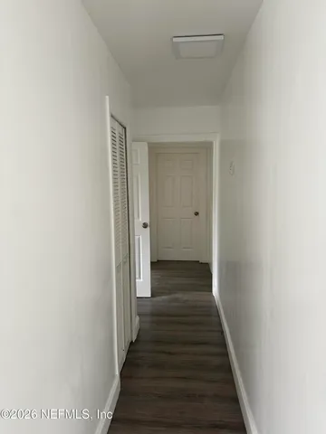 a view of a hallway with wooden floor