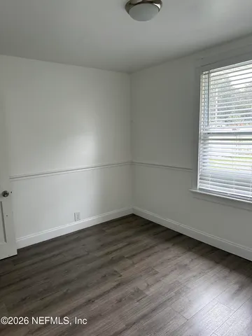a view of a small space with wooden floor and windows