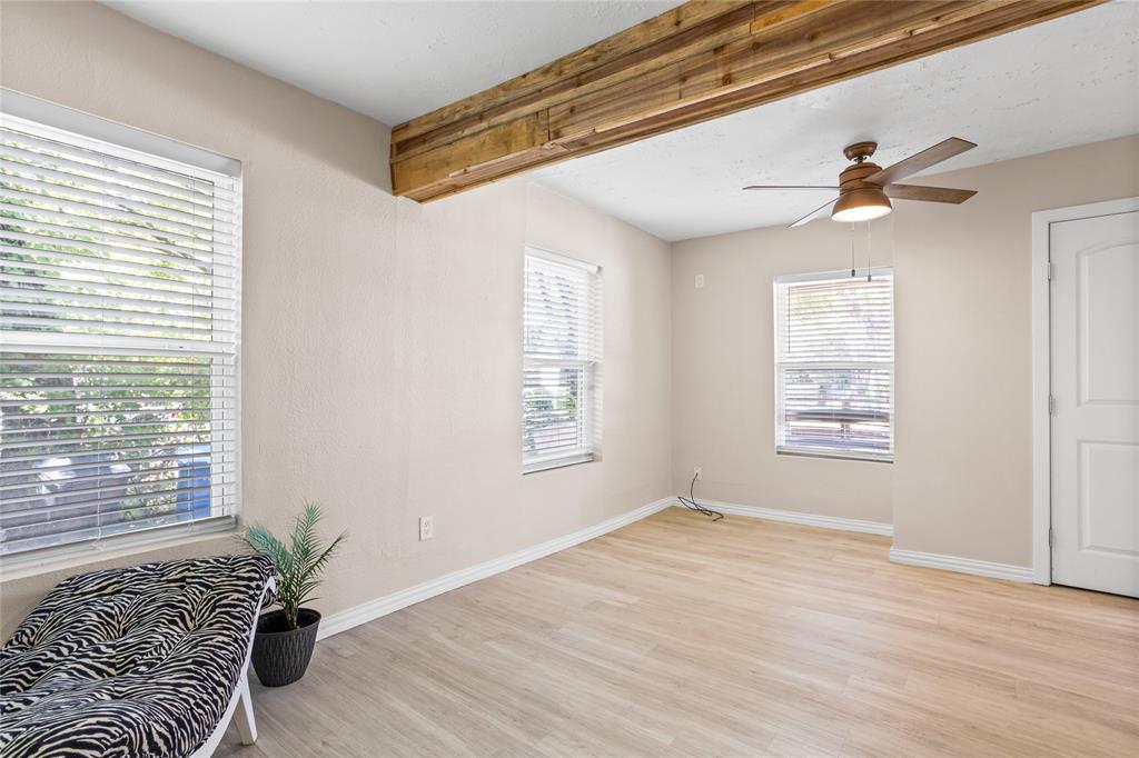 614 Rice Street Denison, TX 75020 - Photo 13 of 22 From the other side of the room, the three windows show the light flooding in, The door on the right goes to the closet for this room.