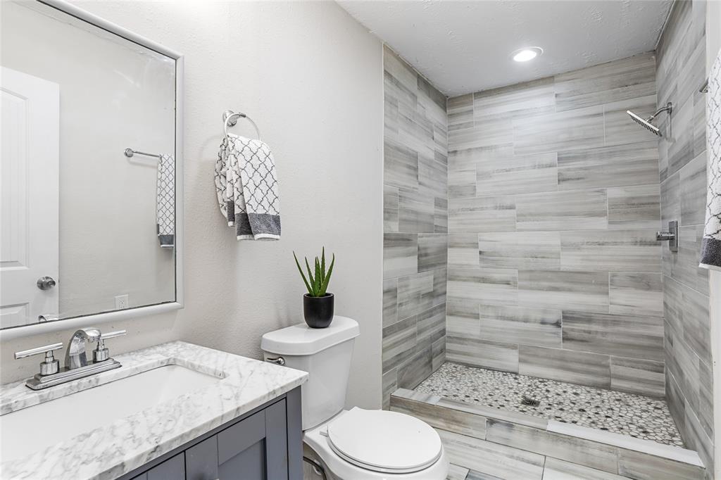 614 Rice Street Denison, TX 75020 - Photo 3 of 22 Two great tiled bedrooms - one in the primary bedroom and one just outside of the kitchen and second bedroom.