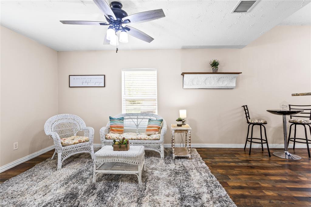 614 Rice Street Denison, TX 75020 - Photo 6 of 22 This living room is shown here with the small dining table beside it, but that could also be on the other side near the bar.