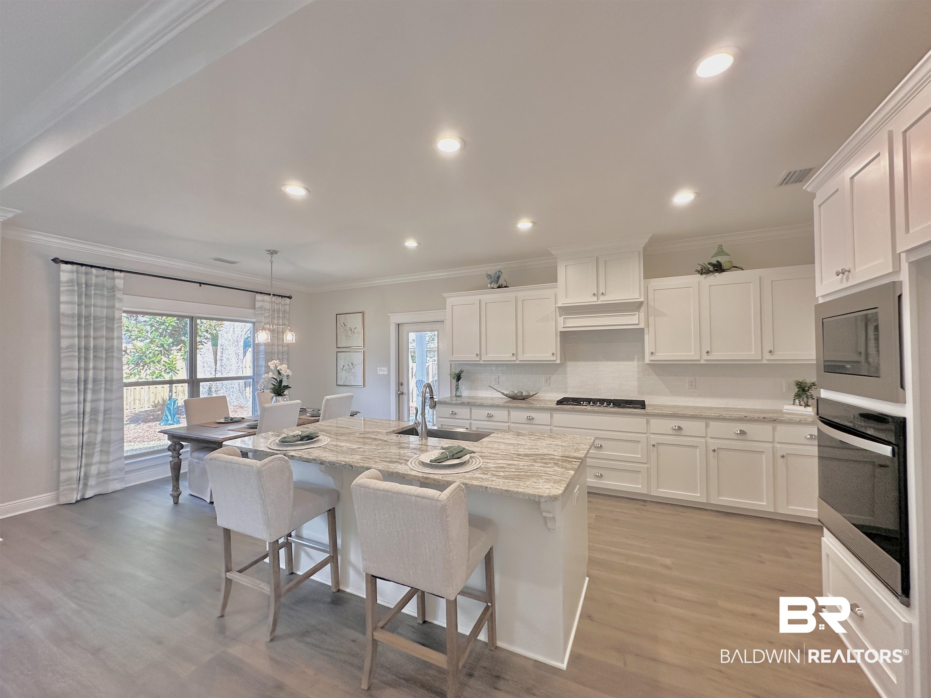 691 Kitfox Avenue Fairhope, AL 36532 - Photo 5 of 42 Kitchen featuring built in microwave, white cabinetry, a center island with sink, and oven