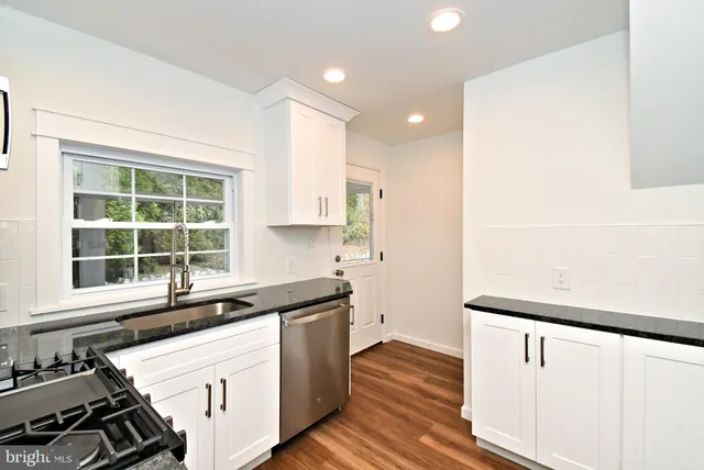 a kitchen with granite countertop a stove and a sink