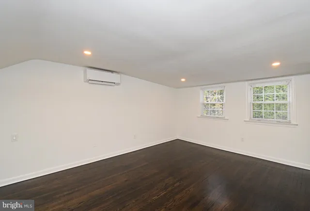 an empty room with wooden floor and white wall