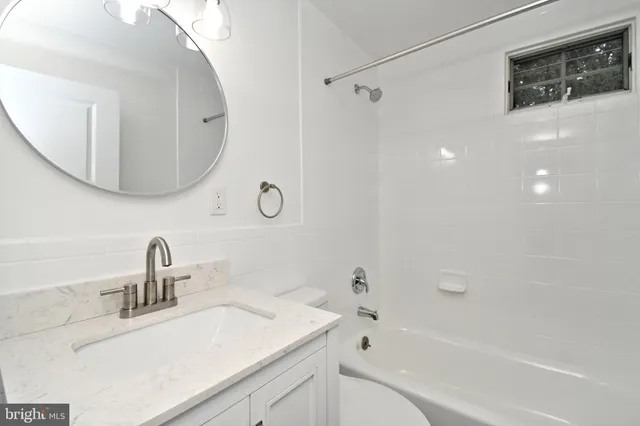 an empty room with wooden floor chandelier fan and windows