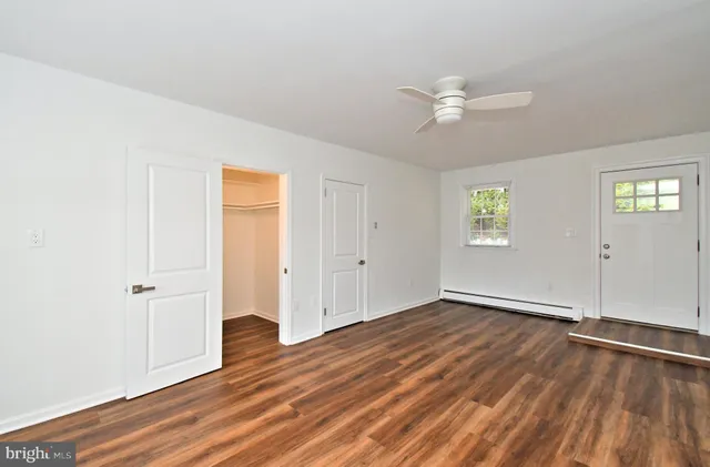 a view of an empty room with wooden floor