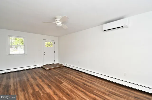 a view of an empty room with wooden floor