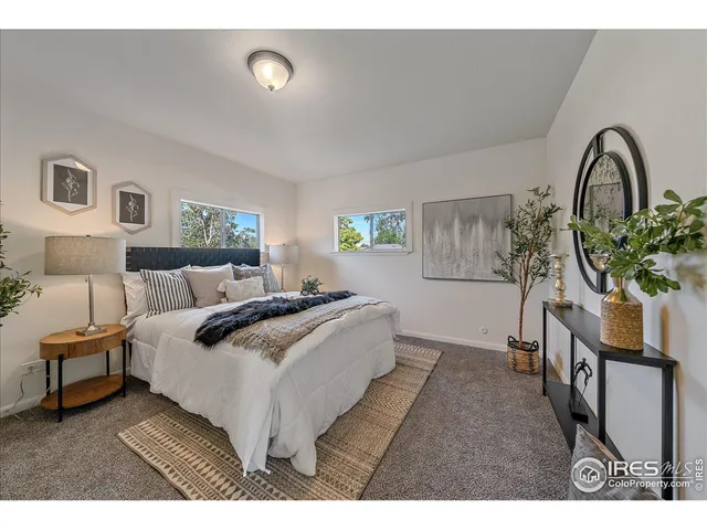 a spacious bedroom with a bed and a potted plant