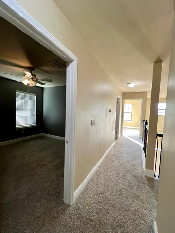 en empty room with windows and ceiling fan