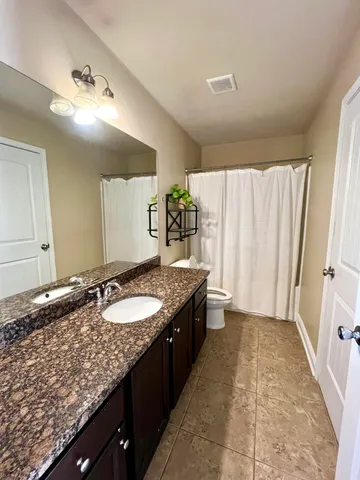 a bathroom with a sink mirror vanity and toilet