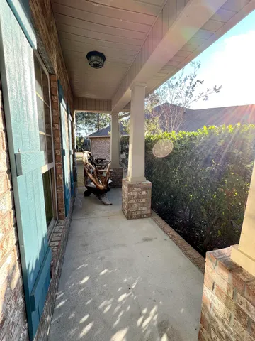an empty room with wooden floor fireplace and windows