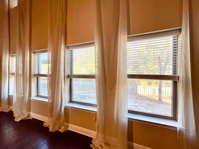 a view of a hallway with wooden floor and windows