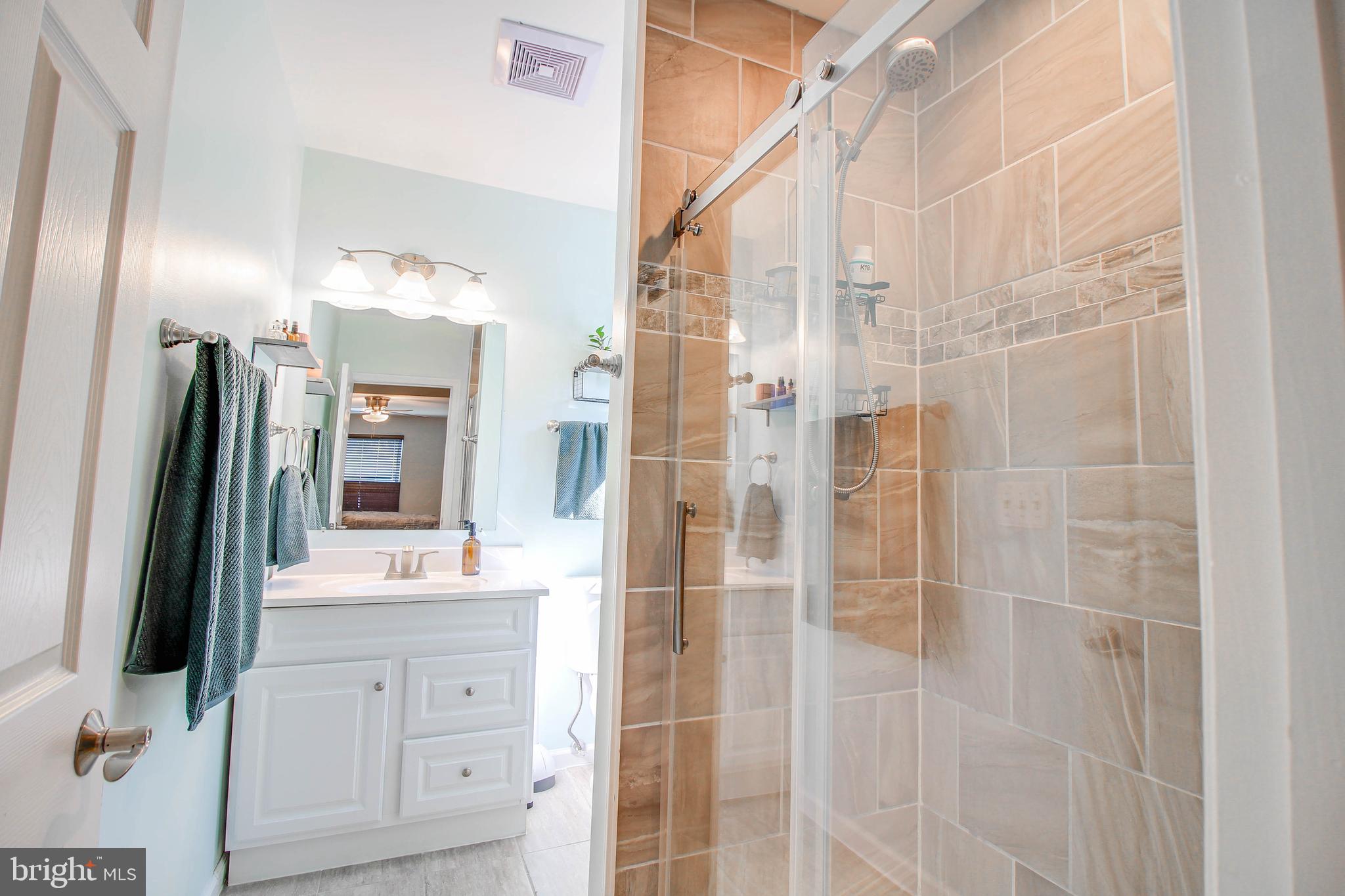 7805 Outing Avenue Pasadena, MD 21122 - Photo 15 of 51 a bathroom with a shower and a mirror