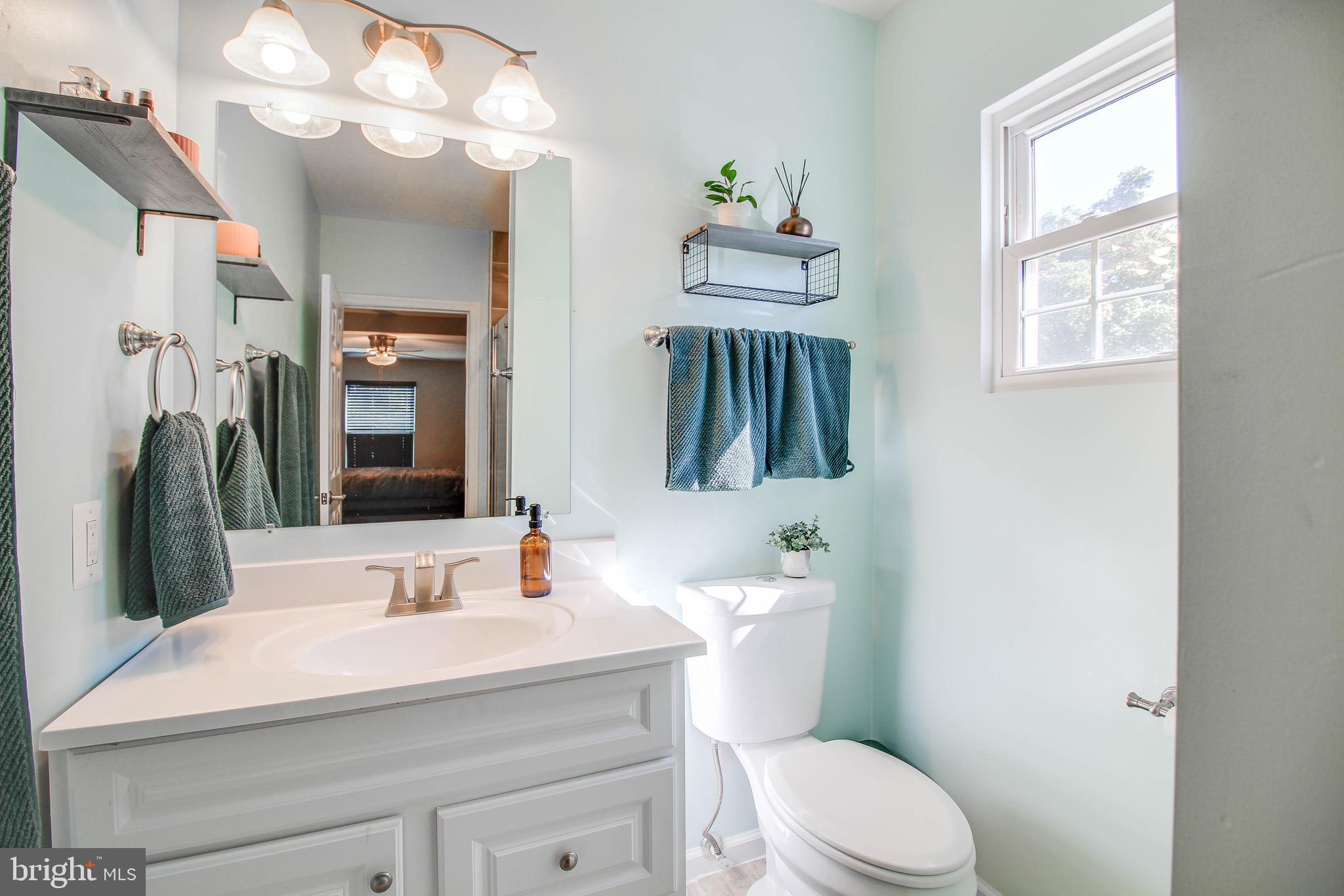 7805 Outing Avenue Pasadena, MD 21122 - Photo 16 of 51 a bathroom with a sink a toilet and a mirror