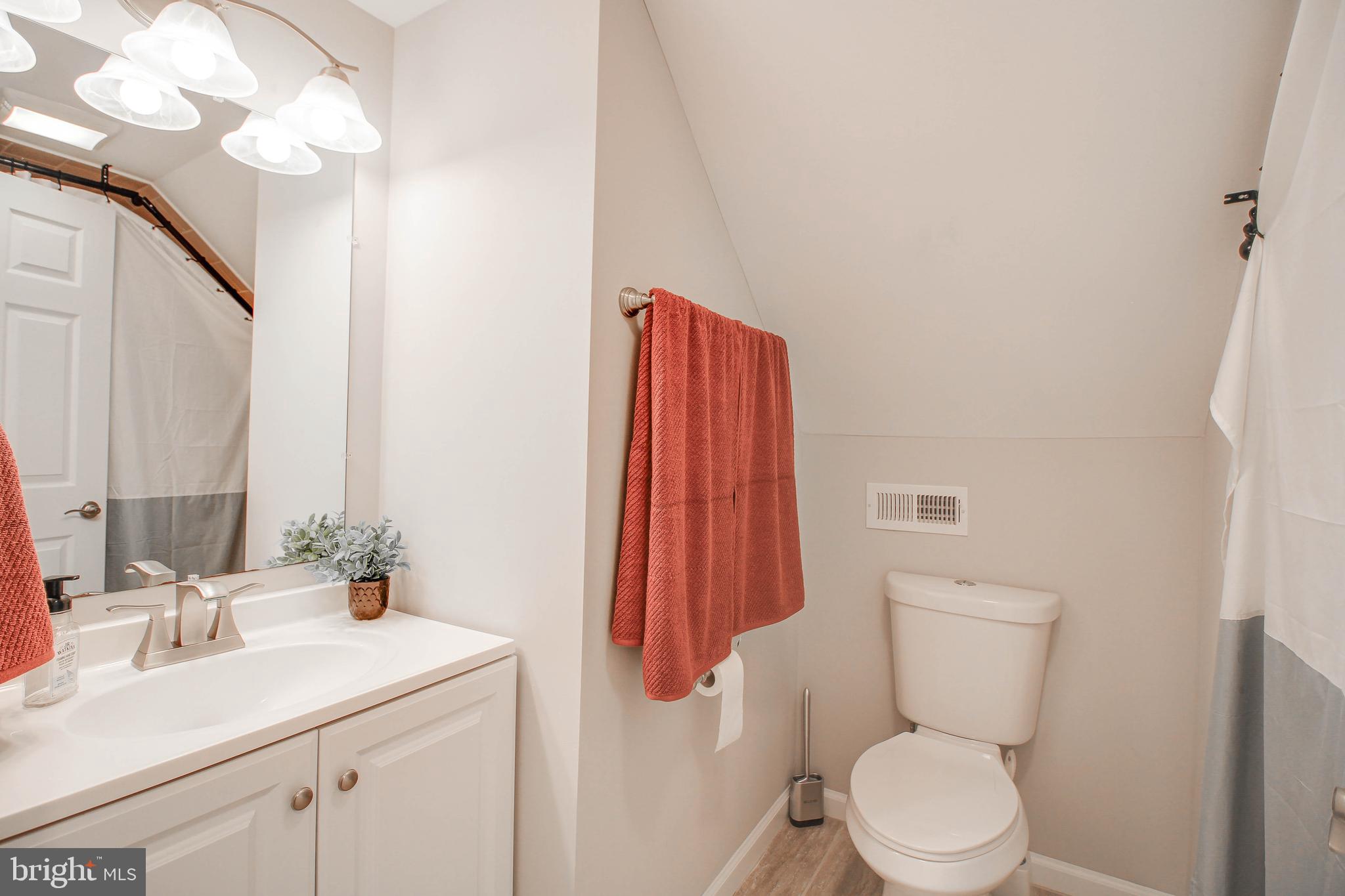 7805 Outing Avenue Pasadena, MD 21122 - Photo 24 of 51 a bathroom with a sink vanity mirror and toilet