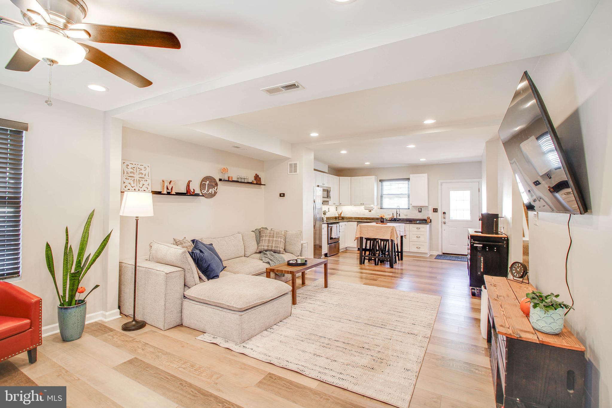 7805 Outing Avenue Pasadena, MD 21122 - Photo 3 of 51 a living room with furniture kitchen view and a potted plant