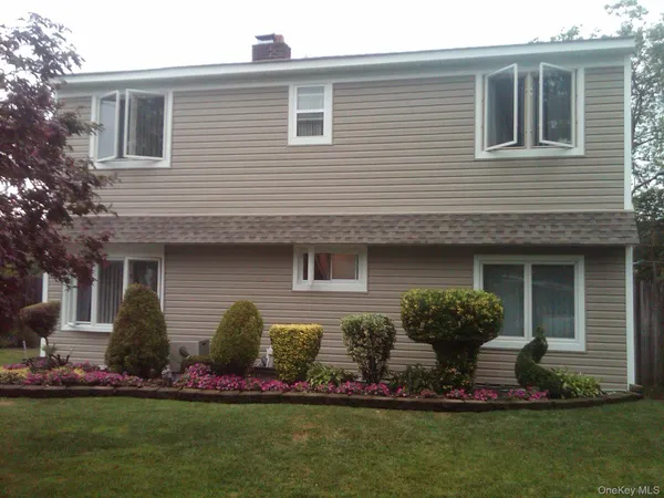 a front view of a house with a garden